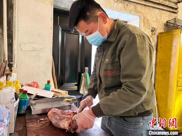 圖為雪豹“奶爸”史壽軍正在準備投喂雪豹的食材?！●R銘言 攝