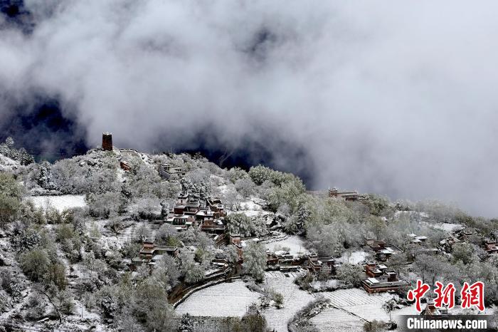 雪后的藏寨和碉樓構(gòu)成美麗的雪景?！〗党鯘衫?攝