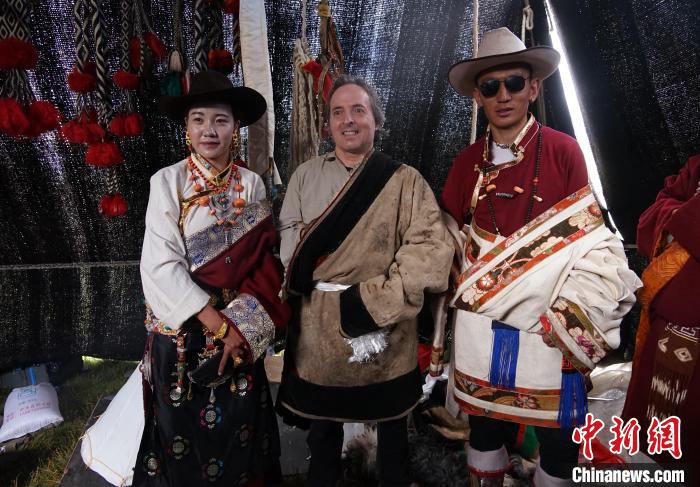 圖為一名外籍攝影師(中)身穿藏服和藏族民眾合影留念?！●R銘言 攝