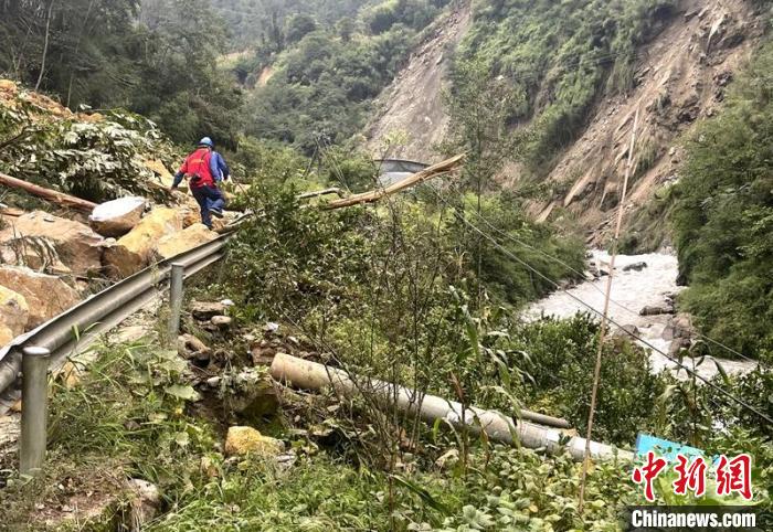 電力搶險人員快速通過危險路段，旁邊是受損的電力線路 四川電力供圖