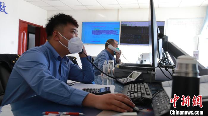 圖為貨運(yùn)調(diào)度人員與外勤工作人員聯(lián)系掌握車輛裝載情況?！±钌?攝