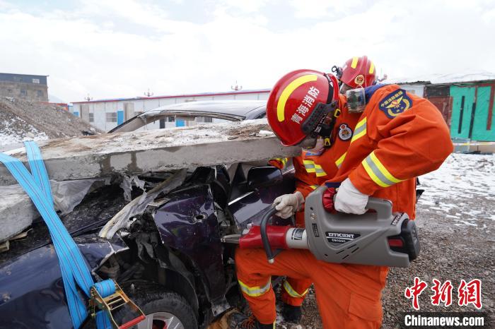 圖為地震實戰(zhàn)拉動現(xiàn)場，參演人員進行車輛破拆?！∮駱湎拦﹫D