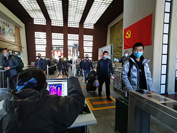 拉薩火車站工作人員對出站旅客進行紅外線測溫。趙越拍攝.jpg