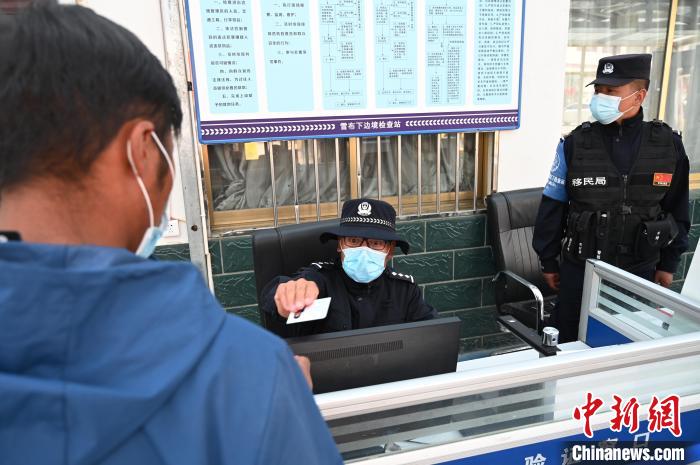 圖為移民管理警察登記完身份信息后將證件歸還給行人。　趙朗 攝