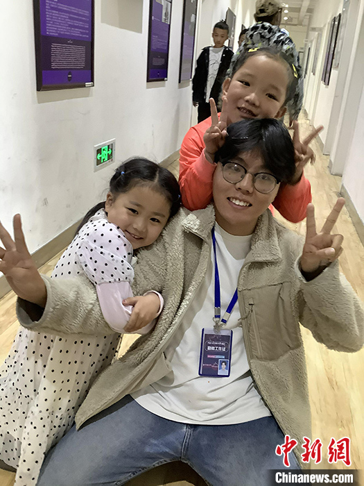 “Z世代”旦真旺加認(rèn)為，拉薩是一座開放與包容的城市，記憶中的拉薩是彩色的。2021年，旦真旺加從浙江大學(xué)漢語(yǔ)言文學(xué)專業(yè)畢業(yè)后，他選擇回到拉薩，成為一名漢語(yǔ)文實(shí)習(xí)助教。圖為8月4日，旦真旺加在課間陪學(xué)生玩耍。 <a target='_blank' ><p  align=