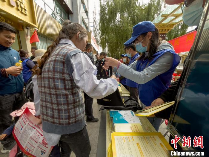 圖為志愿者為市民發(fā)放網(wǎng)絡(luò)安全宣傳手冊?！≈x牧 攝