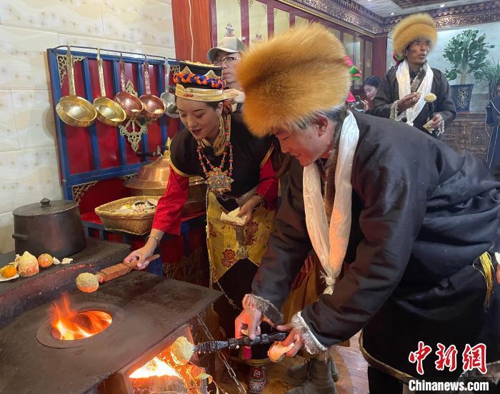 圖為人們在火上烤節(jié)日美食“結(jié)達”。　冉文娟 攝