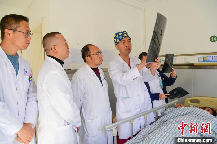 圖為醫(yī)療援藏專家何蔚(站右二)與馮敬云(左二)、廖濤(左三)等人討論患者病情。(資料圖) 貢嘎來(lái)松 攝