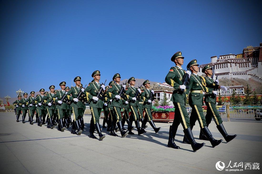 國旗護衛(wèi)隊隊員緊握鋼槍，踏著威武雄壯的步伐，走向國旗臺。人民網(wǎng) 次仁羅布攝