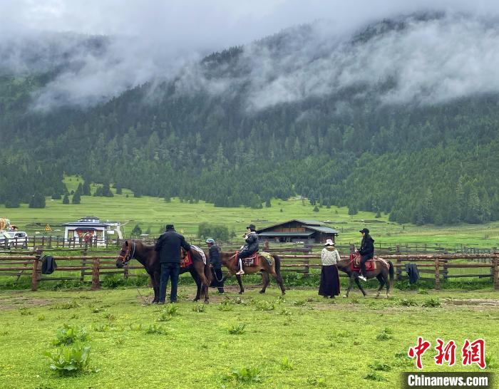 6月10日，游客在魯朗小鎮(zhèn)高山牧場(chǎng)景區(qū)體驗(yàn)騎馬?！∪轿木?攝