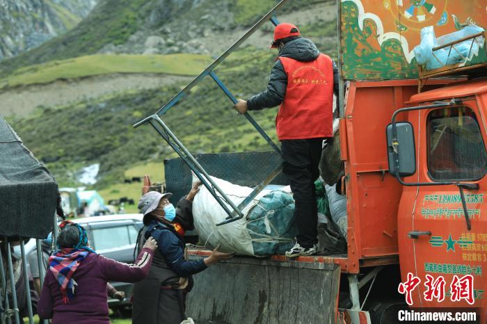 圖為工作人員幫助牧民們卸家具?！÷蹇?攝
