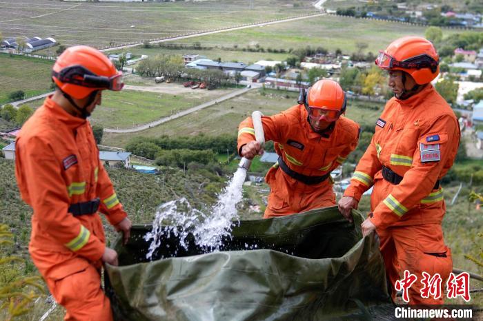 技能大練兵過程中，消防員在陡坡上向蓄水池注水?！±顕鵂c 攝