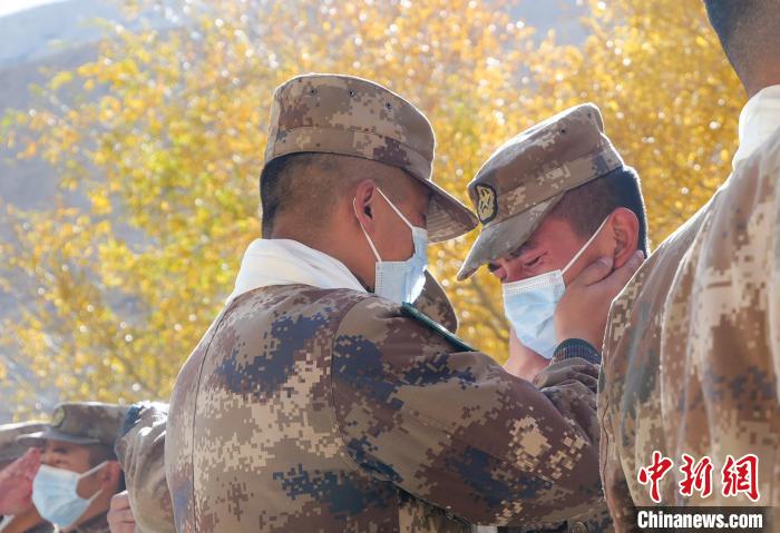圖為什布奇邊防連退伍老兵與戰(zhàn)友相擁而泣，依依惜別?！⌒觳?攝
