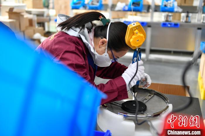 圖為工人正在組裝炊具。　貢嘎來(lái)松 攝