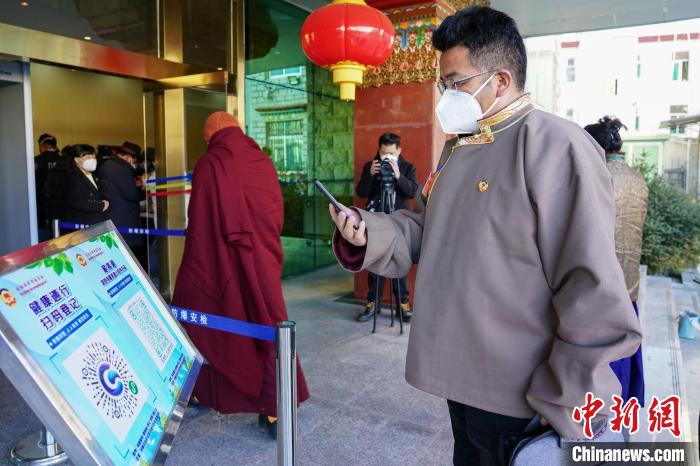 圖為政協(xié)委員掃場所碼進(jìn)入會(huì)場?！〗w波 攝
