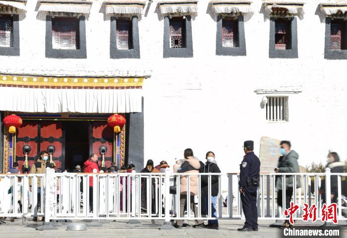 圖為1月23日，布達拉宮廣場派出所民警正在引導(dǎo)游客?！∝暩聛硭?攝