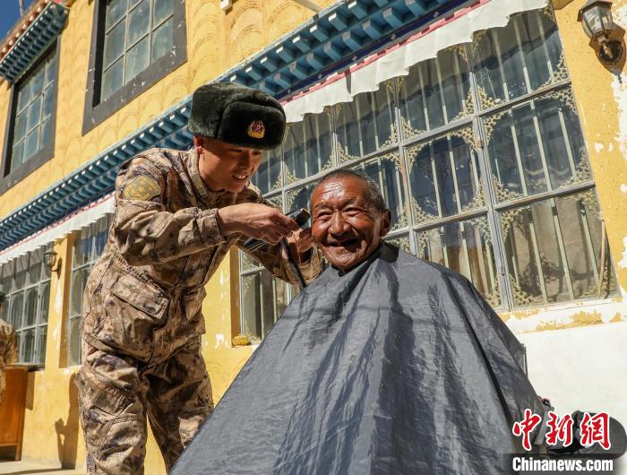 圖為阿里軍分區(qū)某邊防團官兵為駐地群眾理發(fā)迎藏歷新年?！〉┰鰝愔?攝