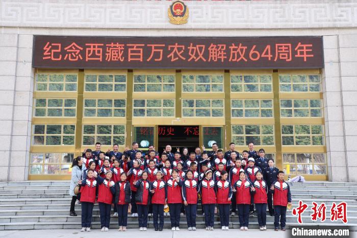 圖為亞?wèn)|邊檢站民警代表與駐地小學(xué)師生代表合影留念。　胡利媛 攝