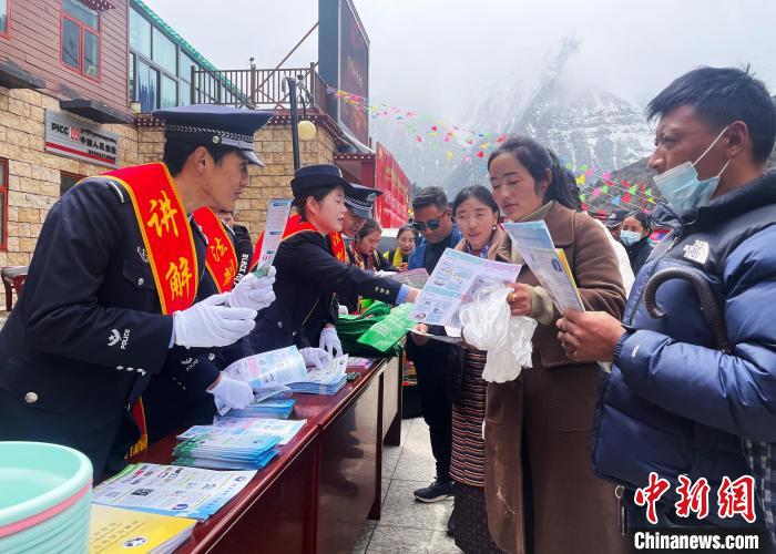 圖為山南玉麥邊境派出所民警為轄區(qū)群眾發(fā)放法律知識(shí)宣傳單。　鐘鑫 　攝