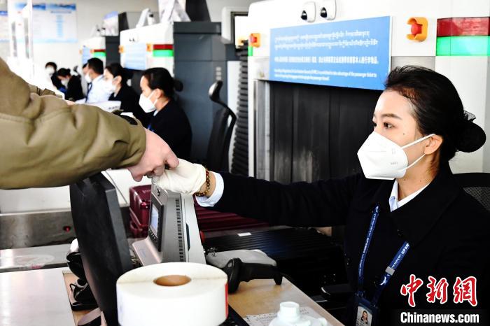 圖為機(jī)場工作人員為旅客辦理行李托運(yùn)?！≈芎?攝