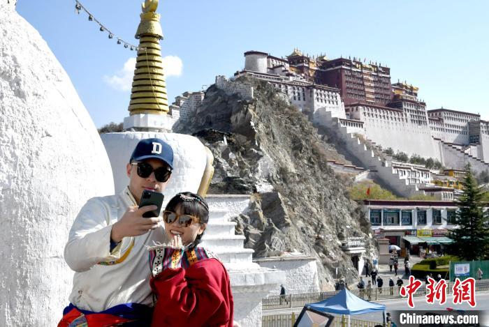 4月17日，游客身著藏式元素服裝在拉薩布達(dá)拉宮觀景臺(tái)拍照留念?！±盍?攝