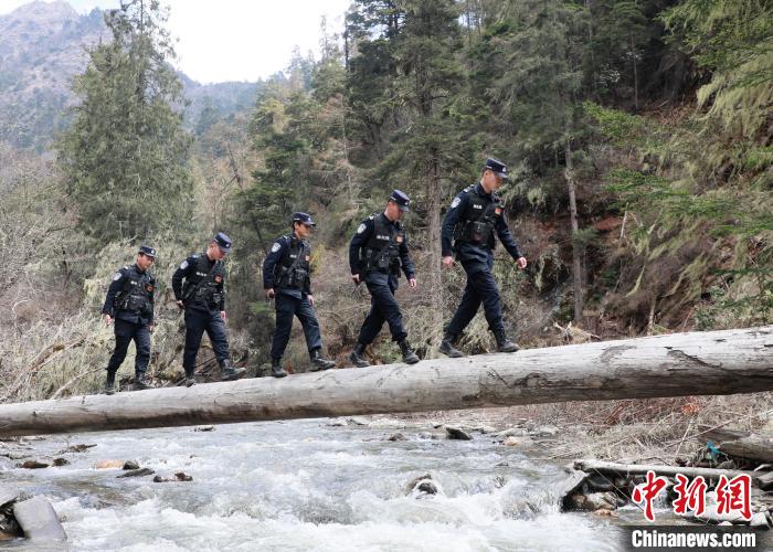 山南邊境管理支隊(duì)玉麥邊境派出所民警邊境巡邏途中走過河道上“獨(dú)木橋”。　鄭琦山 攝
