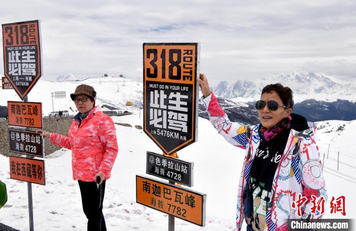 圖為5月14日，西藏林芝色季拉山觀景臺，游客與南迦巴瓦峰合影?！±盍?攝