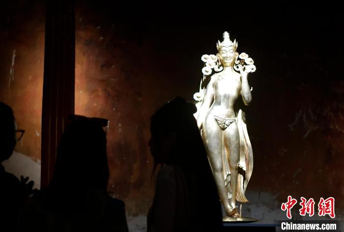 圖為觀眾正在欣賞展覽中的雕塑作品《八萬四千年》?！±盍?攝