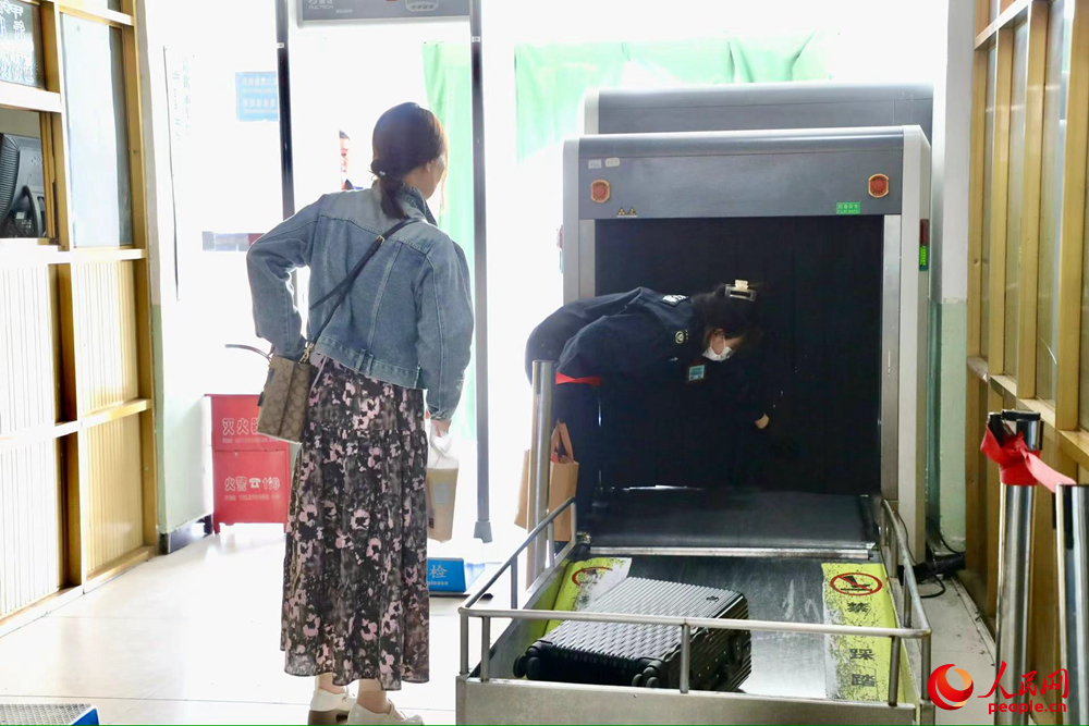 車站工作人員幫旅客提取行李。人民網(wǎng)記者 次仁羅布攝